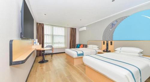une chambre d'hôtel avec deux lits et un bureau dans l'établissement City Comfort Inn Liuzhou Ma'anshan Rongjun Road, à Liuzhou