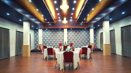 a banquet hall with tables and red chairs in a room at Staynest Continetal With parking Near Mg Marg in Gangtok