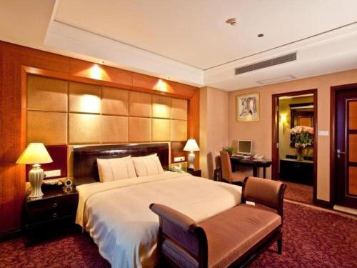 a large bedroom with a large bed and a desk at Chinflux Mandarin Hotel in Dongguan