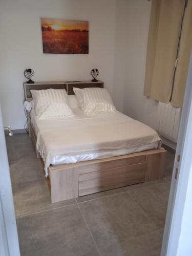 a bed with a wooden frame in a bedroom at Tiny House T1 in Entraigues-sur-la-Sorgue