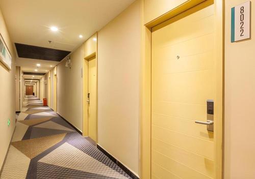 a corridor of a hallway with a door and a tile floor at City Comfort Inn Wuhan Hankou Railway Station West Square in Wuhan