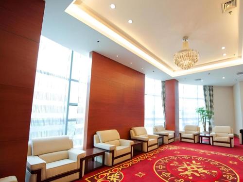 a waiting room with white chairs and a red rug at Kunming Wenhui Hotel in Kunming