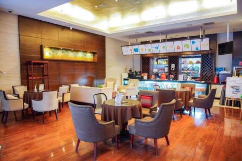a restaurant with tables and chairs and a bar at Kunming Wenhui Hotel in Kunming