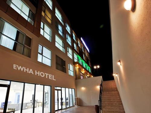 a hotel building with a staircase in front of it at Ewha Hotel in Jeju
