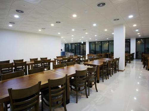 a dining room with wooden tables and chairs at Ewha Hotel in Jeju