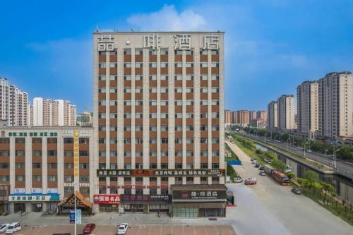 a tall building in the middle of a city at James Joyce Coffetel Tianjin Railway Station Jinshiqiao Metro Station Branch in Tianjin