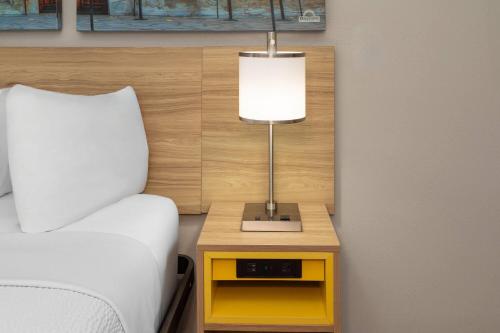 a lamp on a night stand next to a bed at Days Inn by Wyndham Temple in Temple
