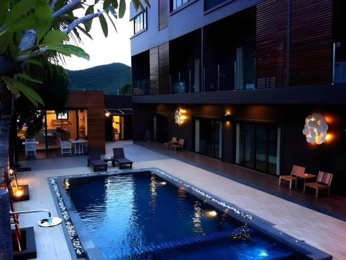 a swimming pool in the backyard of a house at Villa Gris Pranburi in Pran Buri