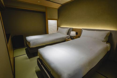 a hotel room with two beds and a window at Kinzan in Kobe