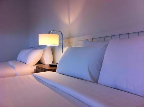 a hotel room with a bed and a lamp at Villa Gris Pranburi in Pran Buri