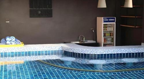 a bathroom with a swimming pool with a sink at Villa Gris Pranburi in Pran Buri