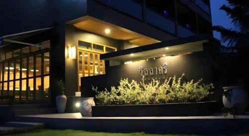 a building with a sign on the side of it at Villa Gris Pranburi in Pran Buri