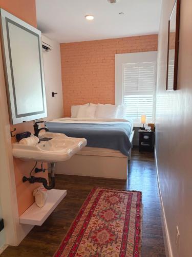 a bedroom with a bed and a sink and a mirror at The Cabot Lodge in Beverly
