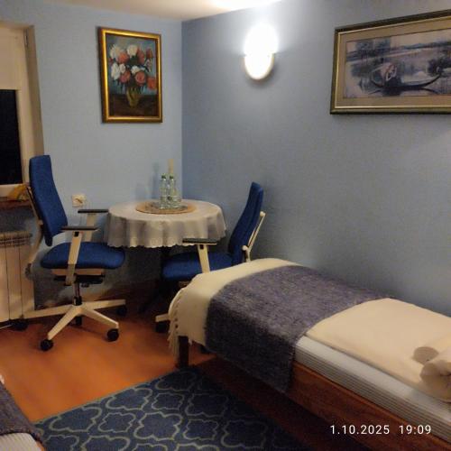 a room with a bed and a table and chairs at Homestay Stróżówka in Gorlice