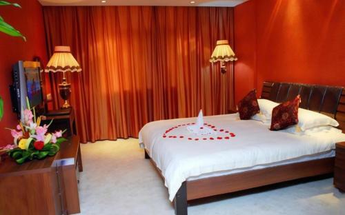 a bedroom with a bed with a candle on it at Huangshan International Hotel in Huangshan