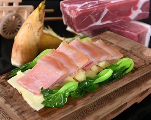 a cutting board with meat and cheese and vegetables at Huangshan International Hotel in Huangshan