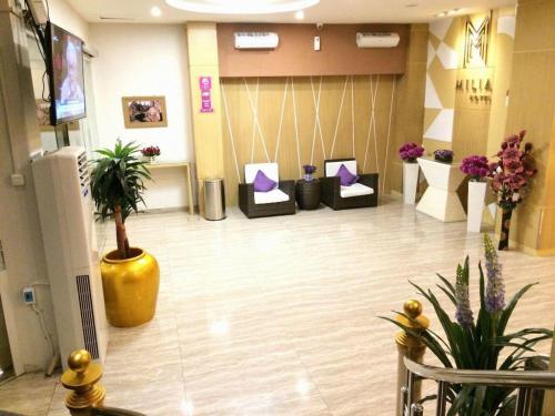 a lobby with a waiting room with chairs and flowers at Hotel D' CaLia Tarakan in Tarakan