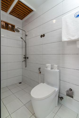 a white bathroom with a toilet and a shower at Quicksand Rasdhoo in Rasdu