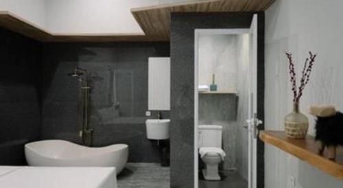 a bathroom with a sink and a toilet and a shower at Kenari Tower Hotel in Makassar