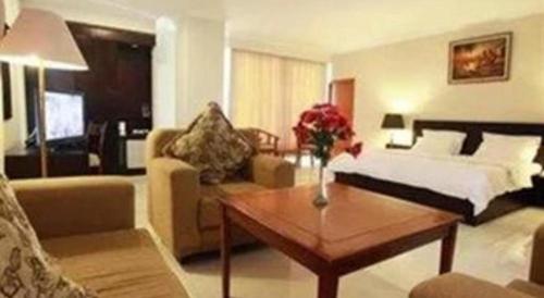 a living room with a bed and a coffee table at Plaza Hotel Tegal in Tegal