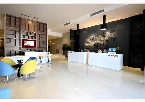 a lobby with people sitting at a counter in a restaurant at Echarm Hotel Beihai Railway Station in Beihai