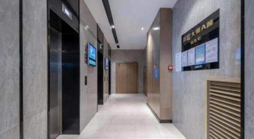 an empty hallway in a building with a elevator at Echarm Hotel Beihai Railway Station in Beihai