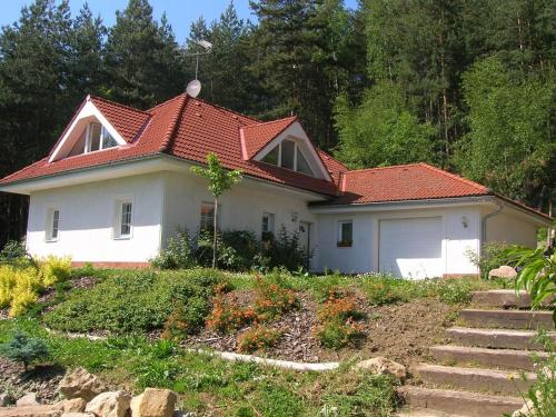 a small white house with a red roof at Comfortable detached house with large garden in Klokočí
