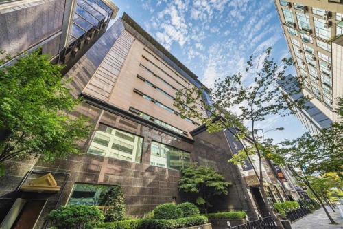 a building on a city street with trees and buildings at Hotel Floce in Bucheon