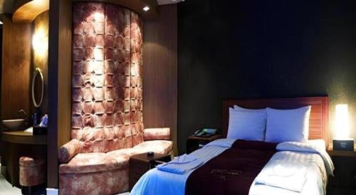 a hotel room with a bed and a chair at Hotel Floce in Bucheon