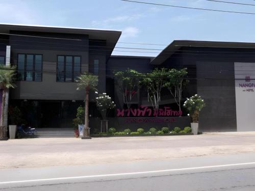 a black building with palm trees in front of it at Nangfa Mini Hotel in Chiang Rai