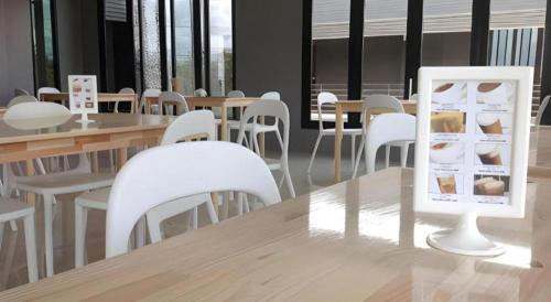 a room with white tables and white chairs and tables at Nangfa Mini Hotel in Chiang Rai