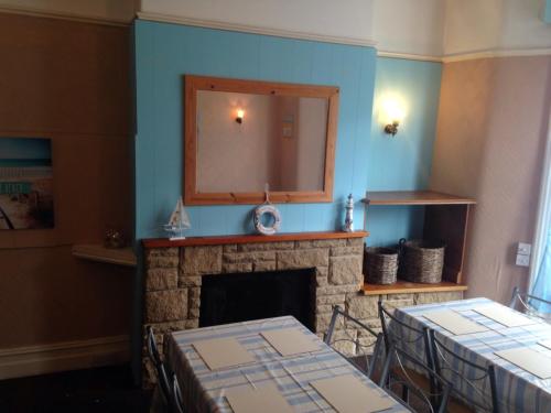 a living room with a fireplace and a mirror at The Driftwood Hotel in Blackpool