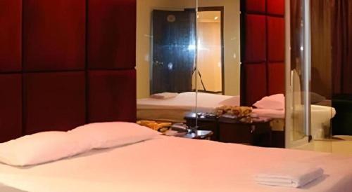 a bedroom with a white bed and a mirror at Out Sky Hotel in Huizhou