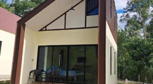a view of a house with a large glass window at At Home Suanphung in Ratchaburi