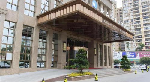 a large building with a staircase in front of it at Clear Lake Hotel in Shanwei