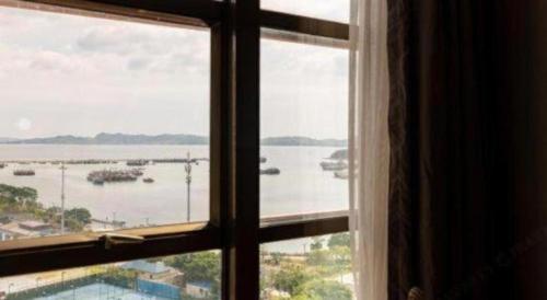 a window with a view of a body of water at Clear Lake Hotel in Shanwei