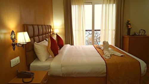 a hotel room with a large bed and a window at The Staynest Yeasel 4 STAR LUXURY RESRT in Gangtok