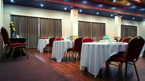 a dining room with tables and chairs with white table cloth at The Staynest Yeasel 4 STAR LUXURY RESRT in Gangtok