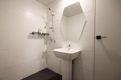 a white bathroom with a sink and a mirror at Hotel Yam ANDONG in Andong