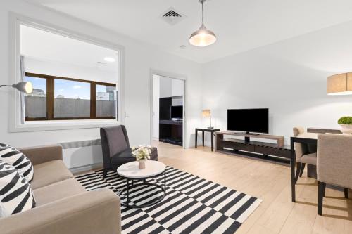 a living room with a couch and a table at Central Emporium Hotel-Style 1BR with King Bed in Melbourne