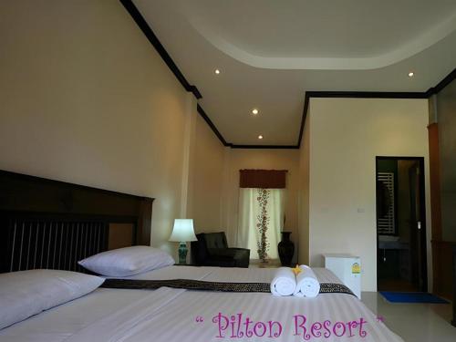 a bedroom with two beds with white sheets and towels at Pilton Resort in Prachuap Khiri Khan