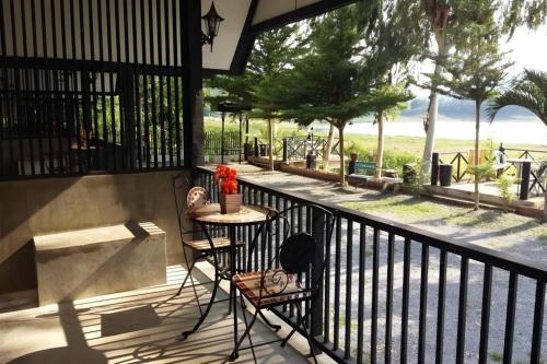 a balcony with a table and chairs and a view at Rim Kaeng resort in Phetchaburi