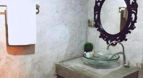 a bathroom with a bowl sink and a mirror at Rim Kaeng resort in Phetchaburi