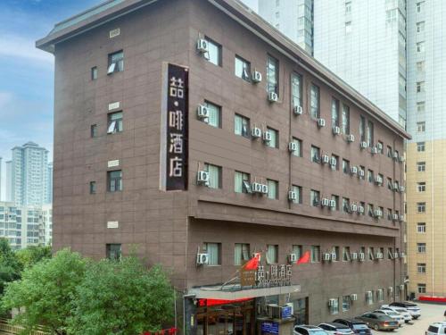 a brown building with a sign on the side of it at James Joyce Coffetel Xi'an Lingtong The Terracotta Army Huaqingchi University Town Metro Station in Xi'an
