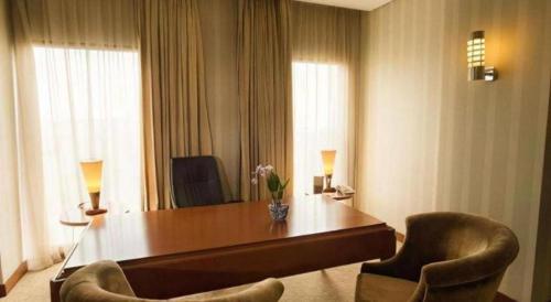 a hotel room with a desk and two chairs at Labersa Grand Hotel &Convention Center in Pekanbaru