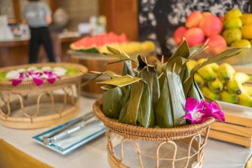 a basket of vegetables on a counter with fruit at LANDMARK NAKHONPHANOM HOTEL in Nakhon Phanom