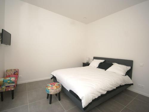 une chambre avec un lit blanc et une chaise dans l'établissement Villa in Var with Pool near Massif Maures, à Vidauban