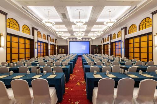 a large room with chairs and a projection screen at Jin Jiang Nanjing Hotel in Nanjing