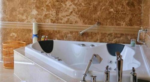 a bathroom with a white bath tub in a room at Grand Metropark Hotel Chongqing in Chongqing