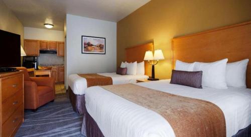 a hotel room with two beds and a kitchen at Best Western Plus Guymon Hotel and Suites in Guymon
